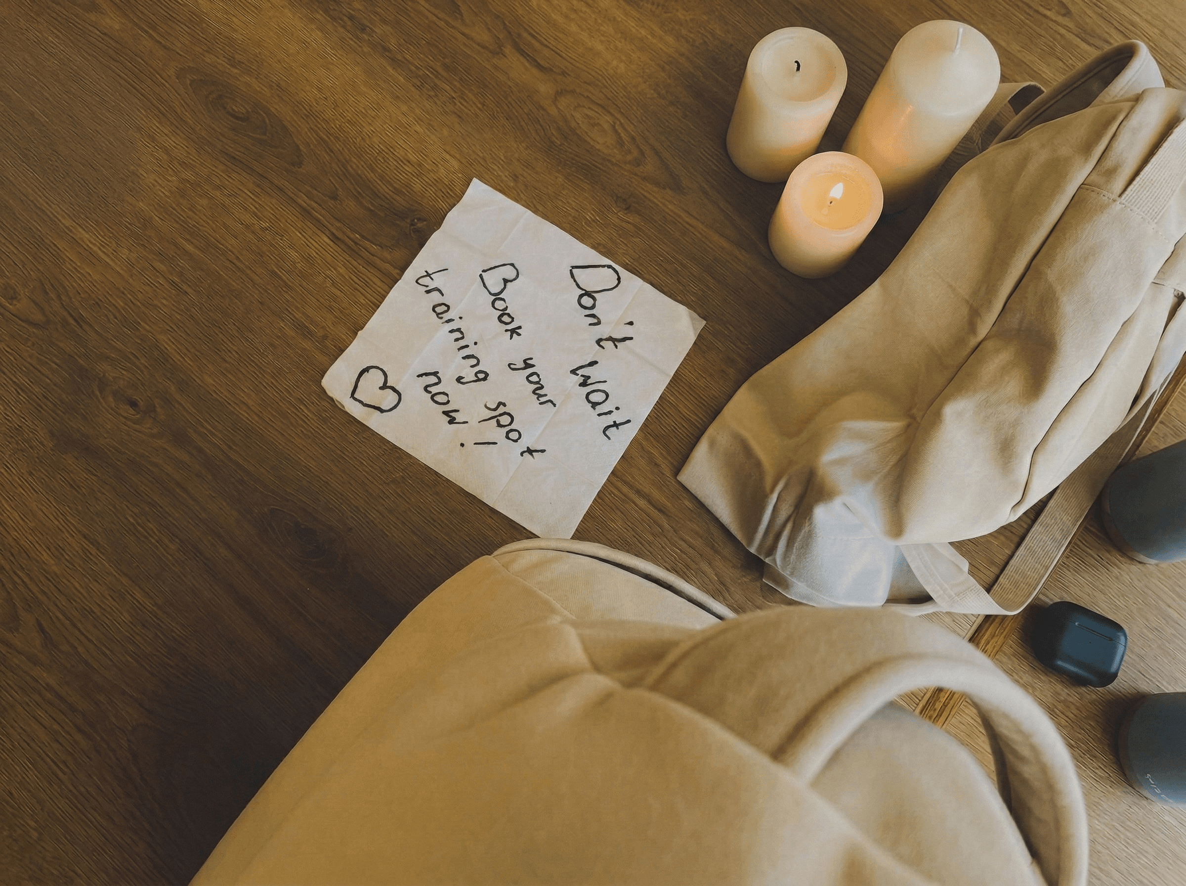 Ръкописна бележка „Не чакай. Запази си място за тренировка сега“ с свещи и спортна чанта
